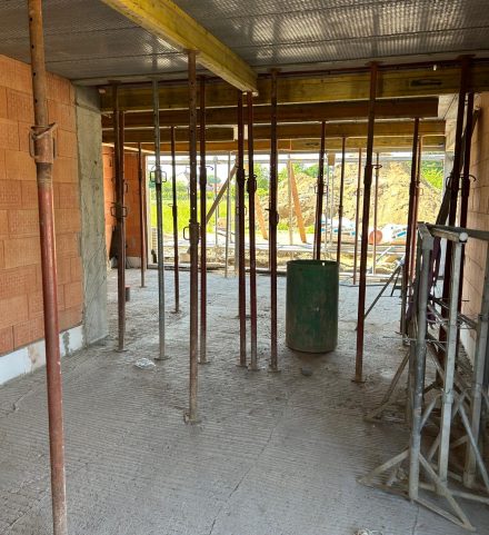 Binnenzicht van een woning in ruwbouw met steunpalen en vloerplaat