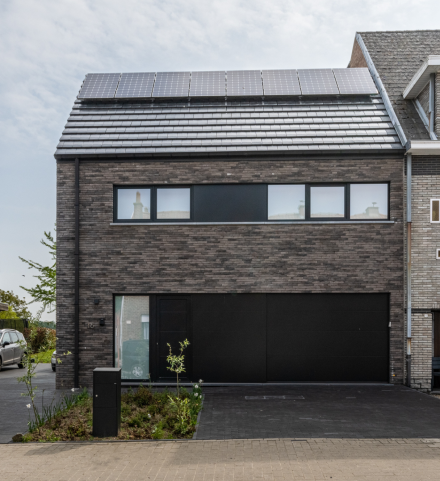 Moderne nieuwbouwwoning met zonnepanelen, waarvoor in 2026 het standaard btw-tarief van 21 % geldt