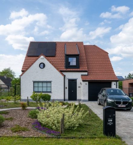 Afgewerkte nieuwbouwwoning met hellend dak en zonnepanelen, voorbeeld van totale bouwkost