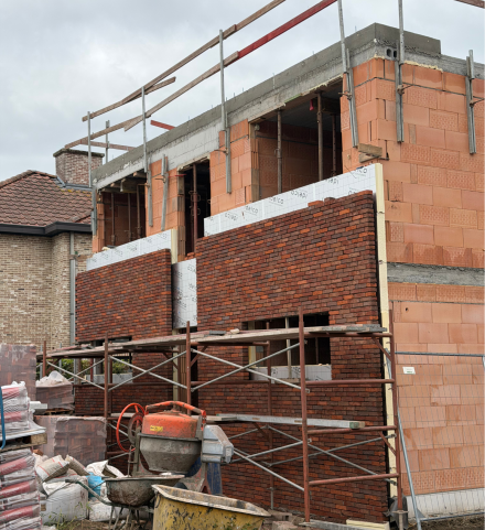 Nieuwbouwproject waarbij isolatie wordt geplaatst tussen de binnenmuur en de gevelsteen.