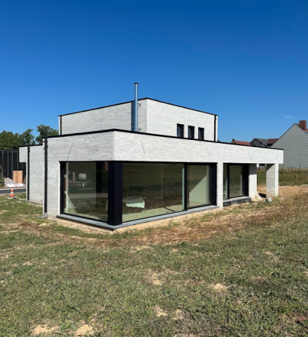 Moderne woning met grote hoekramen en slanke aluminium raamprofielen.